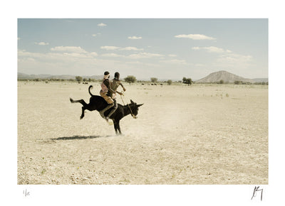 Boys riding a donkey, Damaraland, Namibia, dusty afternoon. | Fine art photographic print by Chad henning