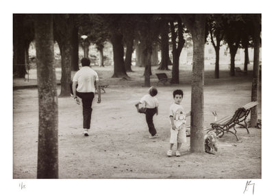 young boy and his father kick a ball in a park in Lisbon, Portugal | Fine art photographic print by Chad Henning